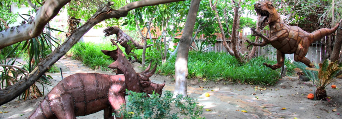 Outdoor garden with wooden dinosaur sculptures